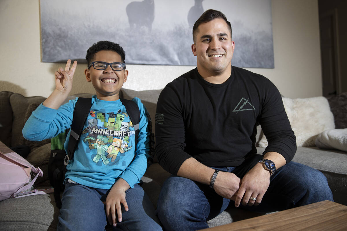 North Las Vegas police officer Nicholas Quintana, right, poses for a photo with his foster chil ...