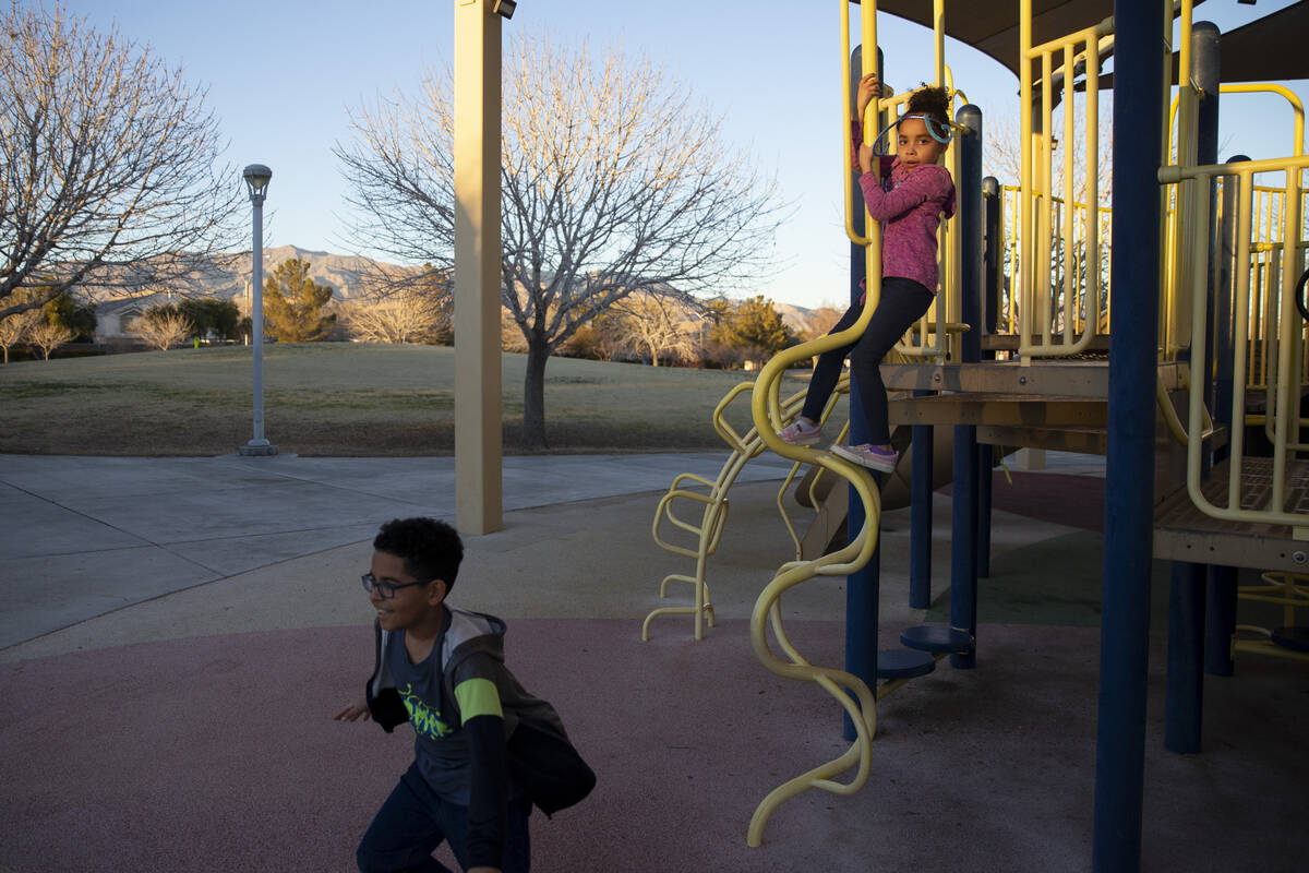 Kristina, right, 6, and her brother Owen, 8, play as their foster parent and North Las Vegas po ...