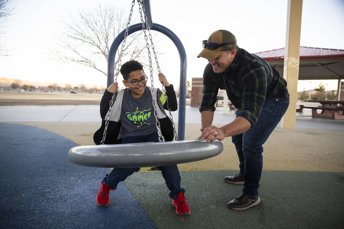 North Las Vegas police officer Nicholas Quintana plays with his foster child Owen, 8, at Deer S ...