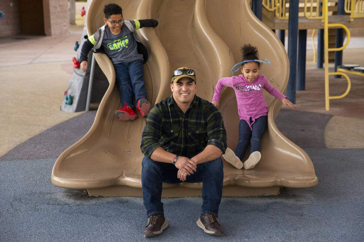 North Las Vegas police officer Nicholas Quintana poses for a portrait with his foster children ...
