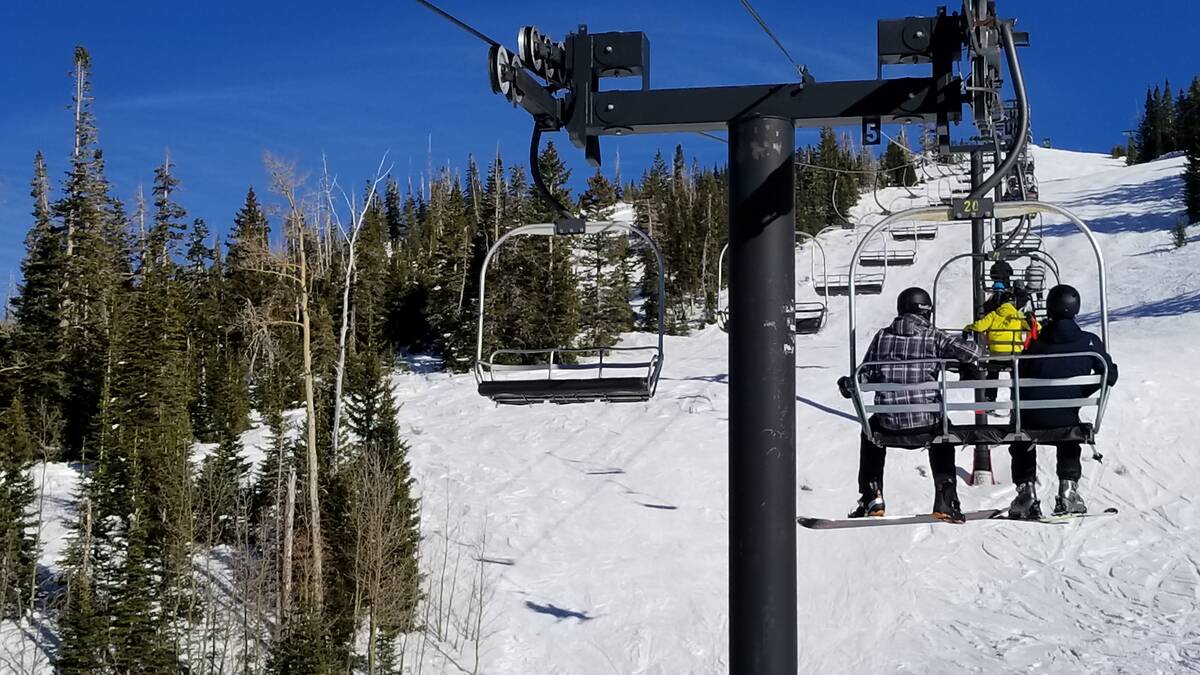 Southern Nevadans ride a Brian Head Resort chairlift in the sunshine on what skiers call a blue ...