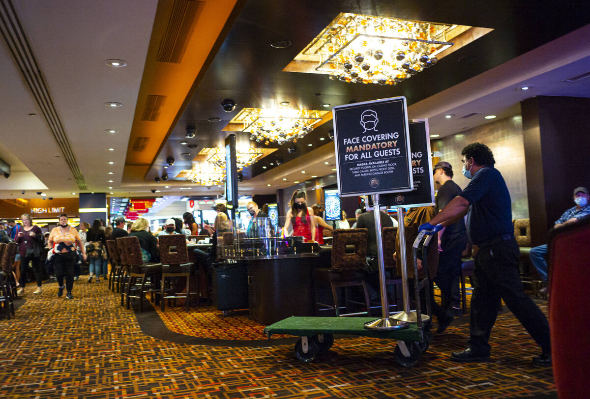 Signs requiring masks are carted away by staff at the Golden Nugget following the end of the ma ...