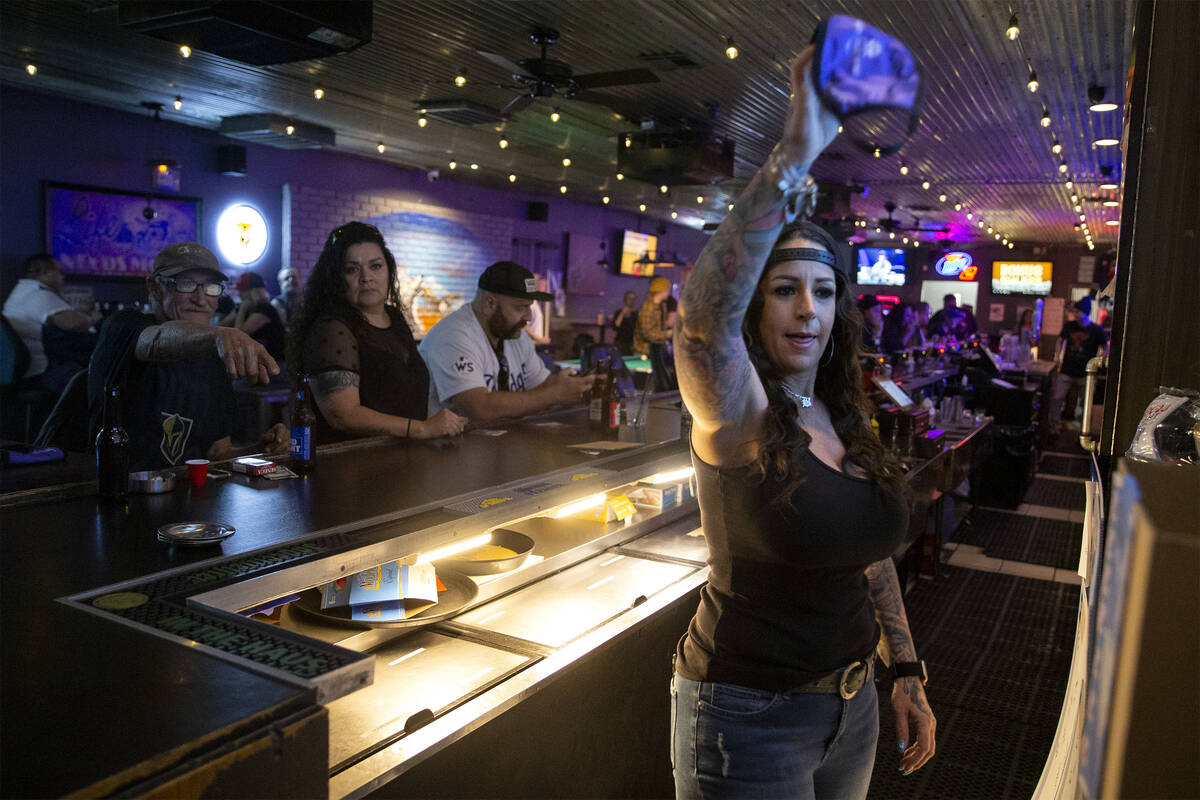 Lindsay Basterrechea, bartender at Gold Mine Tavern, throws away a customer’s mask on Th ...