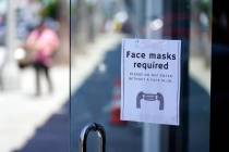 A sign advises shoppers to wear masks outside of a story Monday, July 19, 2021, in the Fairfax ...