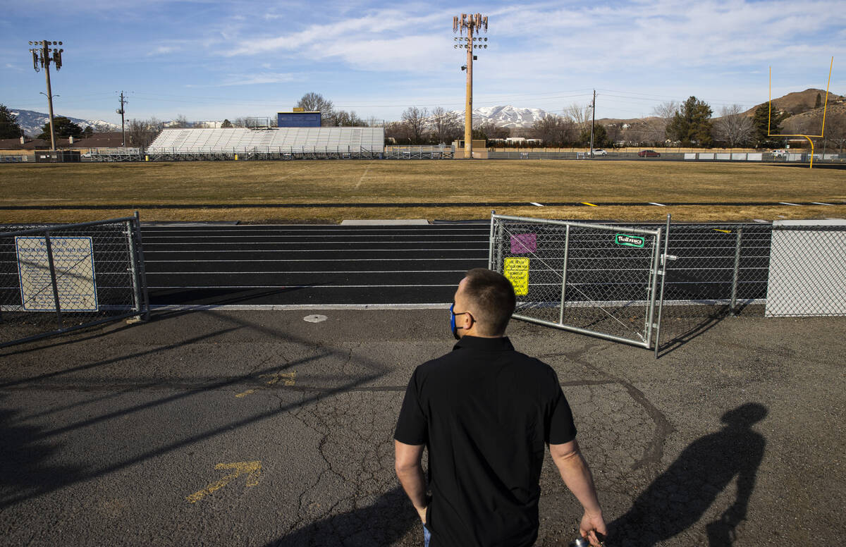 Ryan Sims, athletic director at Reed High School, walks out to the football field on Wednesday, ...