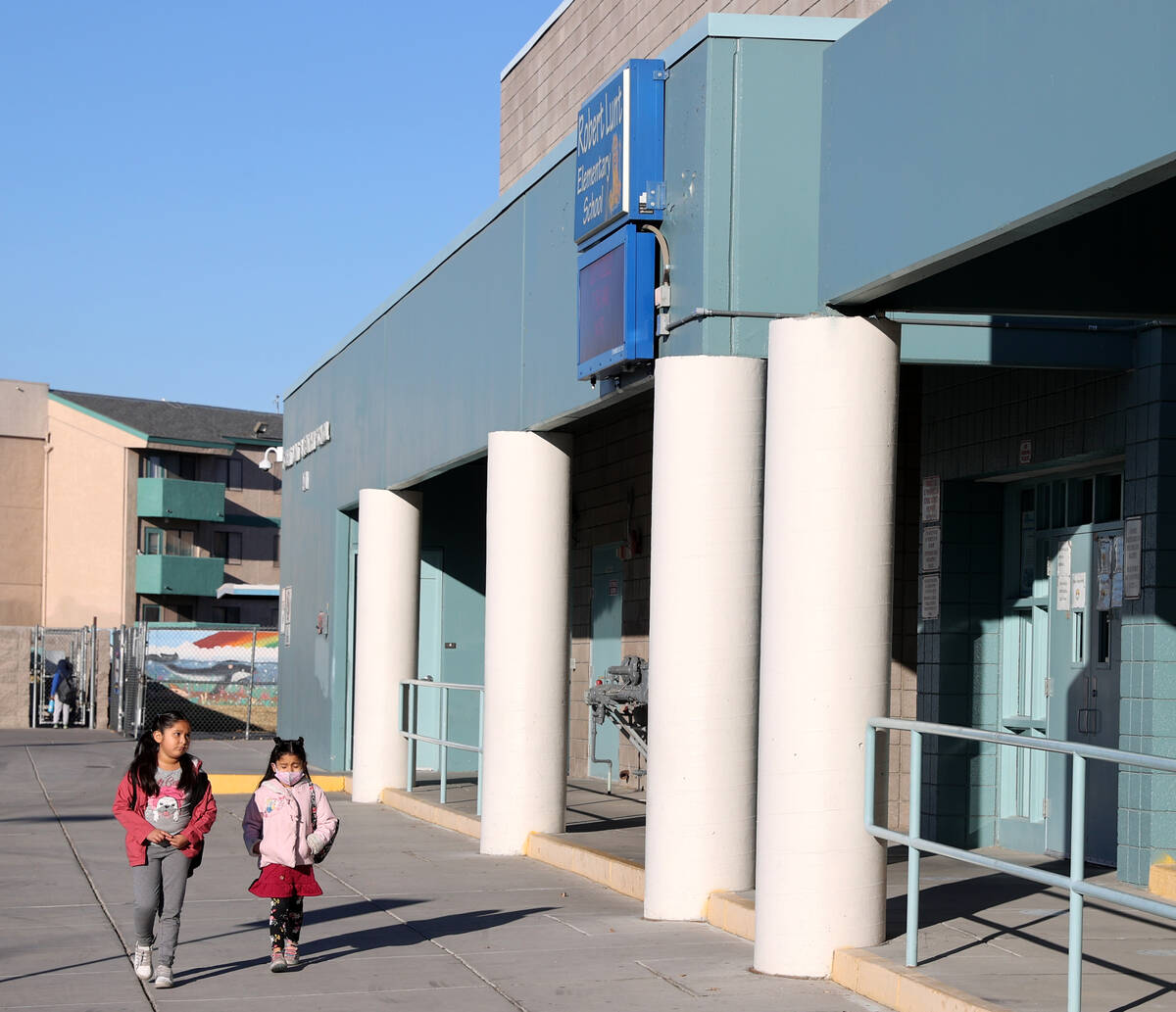 Masked and unmasked students arrive at Lunt Elementary School in Las Vegas Friday, Feb. 11, 202 ...