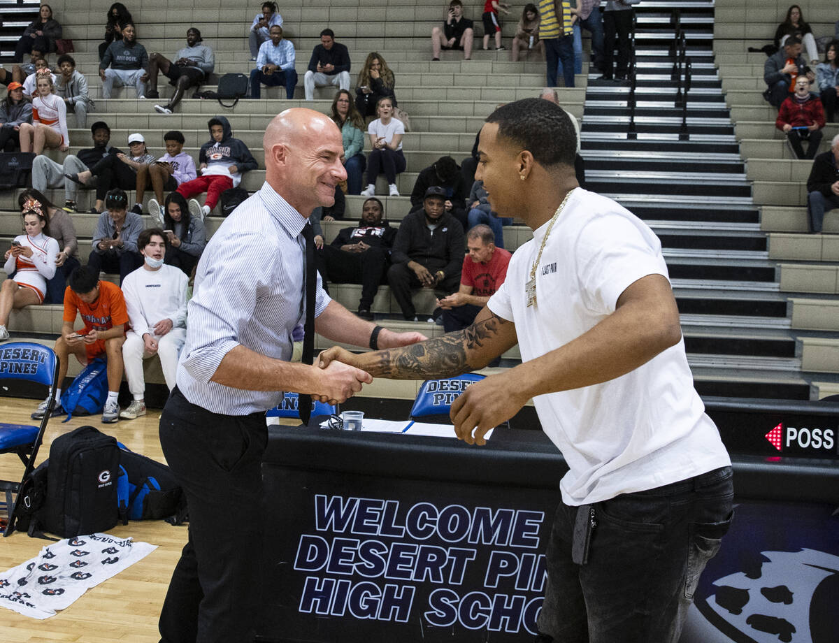 Adam Makos, left, Desert Pines athletic director, congratuates Cleveland Browns linebacker Tony ...