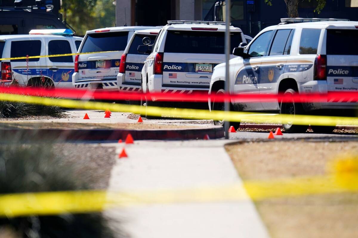 A large police presence is seen in front of a house where five Phoenix Police Department office ...