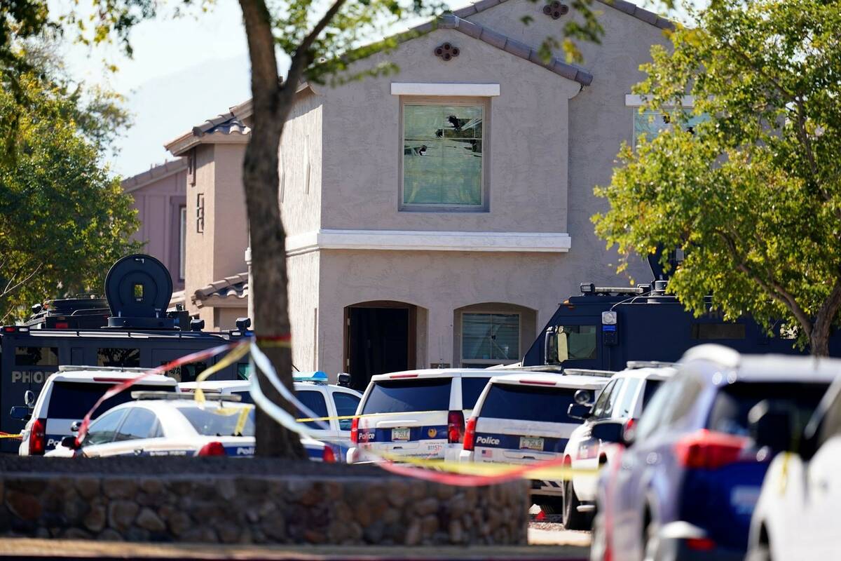 A large police presence is seen in front of a house at the scene of a shooting Friday, Feb. 11, ...