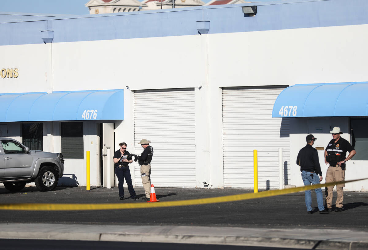 Police investigate the scene where a warehouse employee fatally shot a man who was stealing his ...