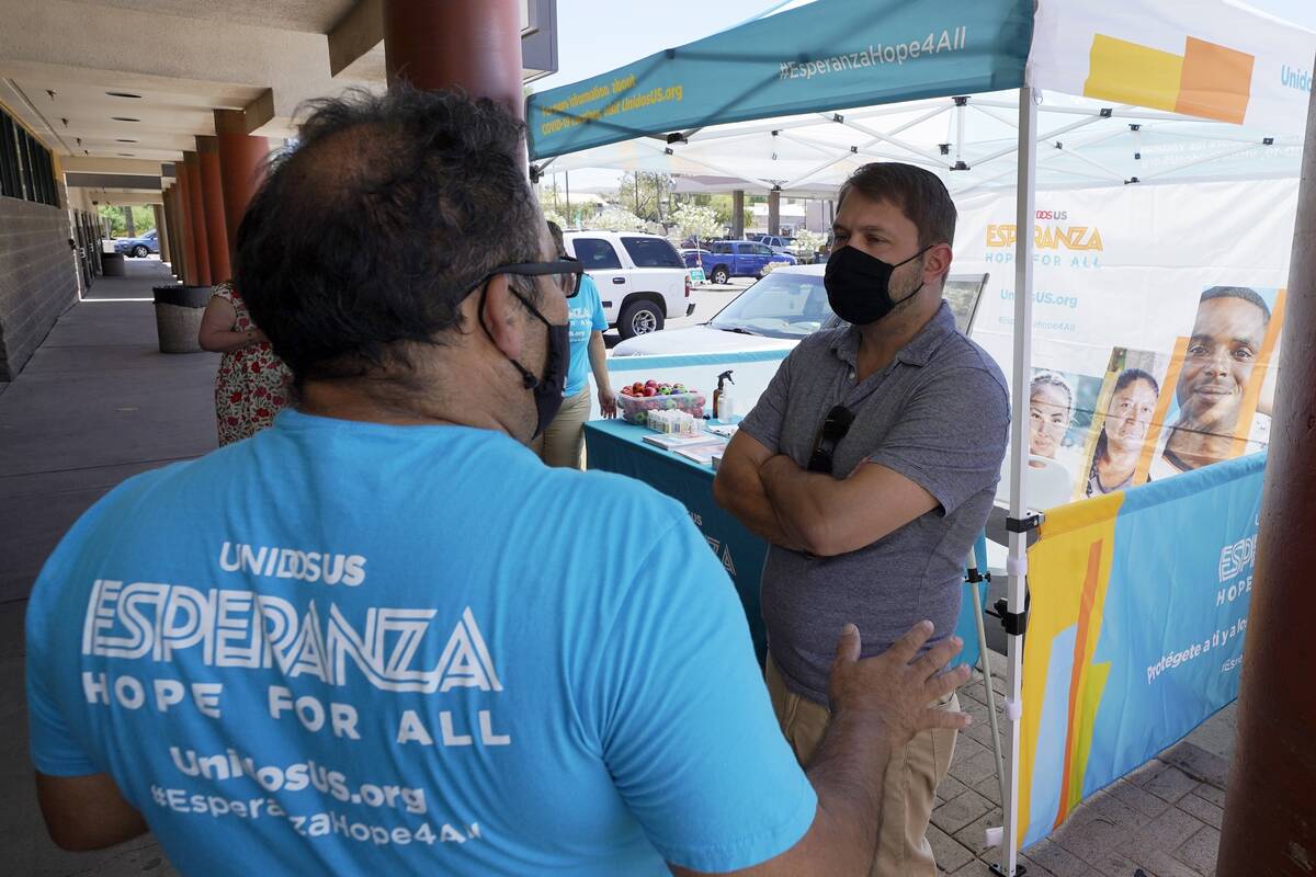 Arizona Democrat Rep. Ruben Gallego, right, talks with Jose Marquez, left, of UnidosUS, at an i ...