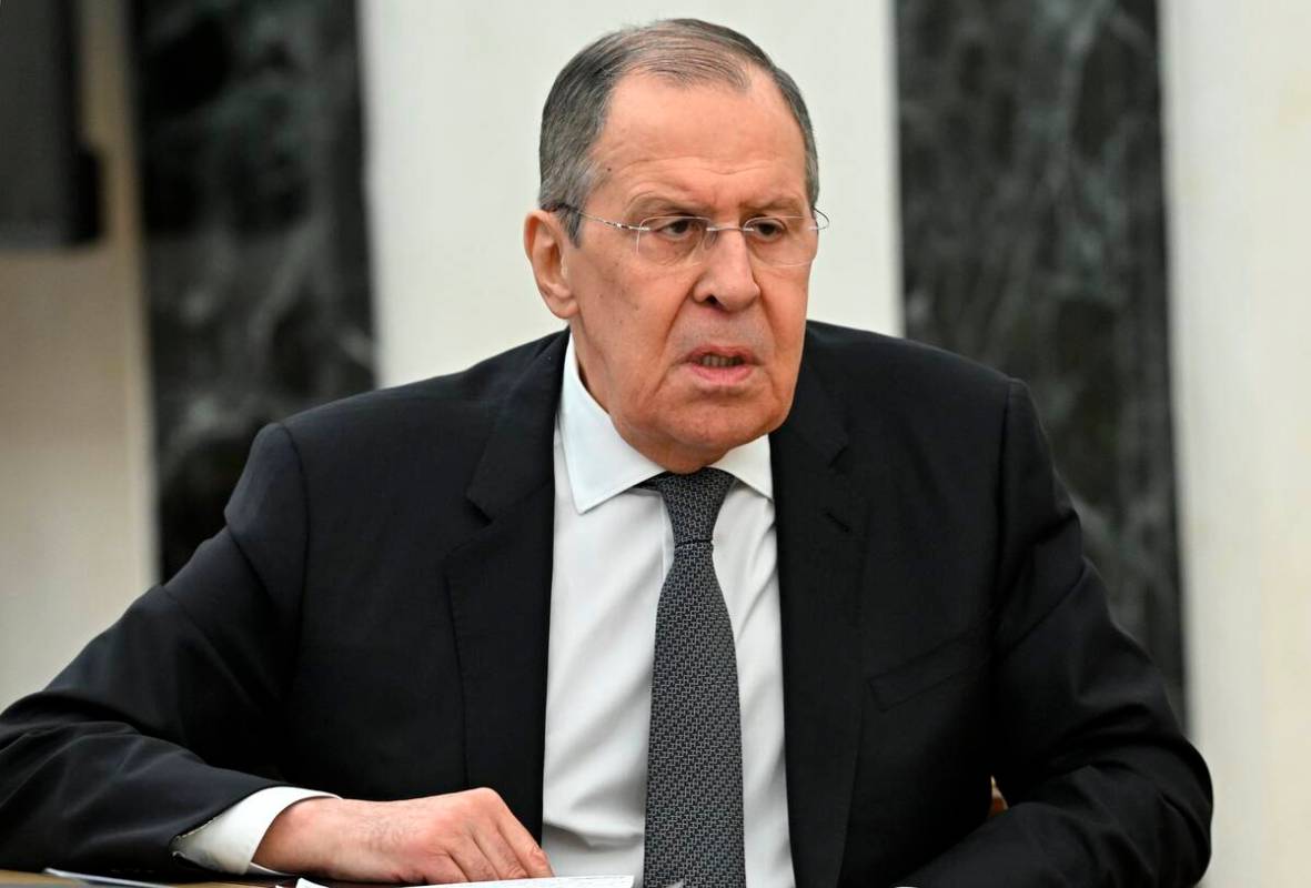 Russian Foreign Minister Sergey Lavrov speaks to Russian President Vladimir Putin during their ...