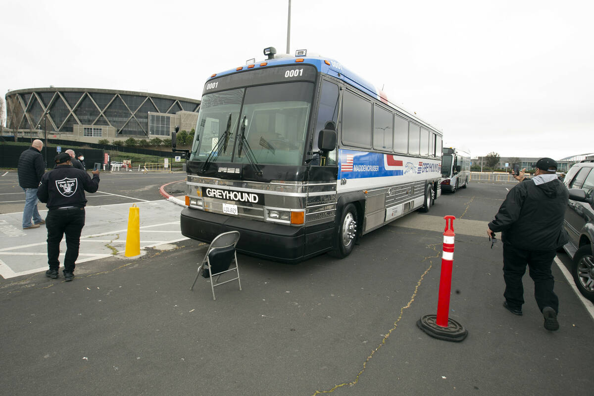 Oakland Raiders fans photograph the "Maddencruiser" bus before a memorial service for ...