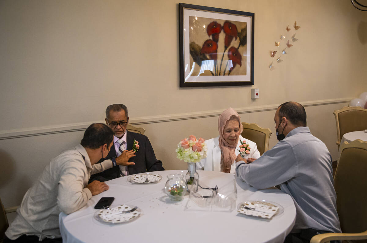 Brothers Orlando Saez, left, and Ben Saez, right, help their parents, Benjamin and Isabel Saez, ...