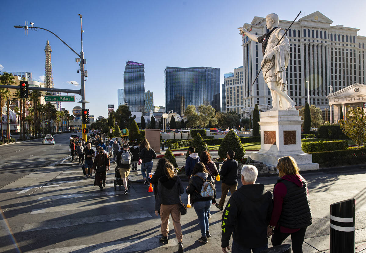 Pedestrians walk along the Las Vegas Strip outside of Caesars Palace on Tuesday, Feb. 15, 2022, ...