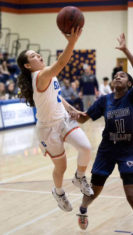 Bishop Gorman guard Selina Gutierrez (12) slices to the rim past Spring Valley's Jaila Childres ...