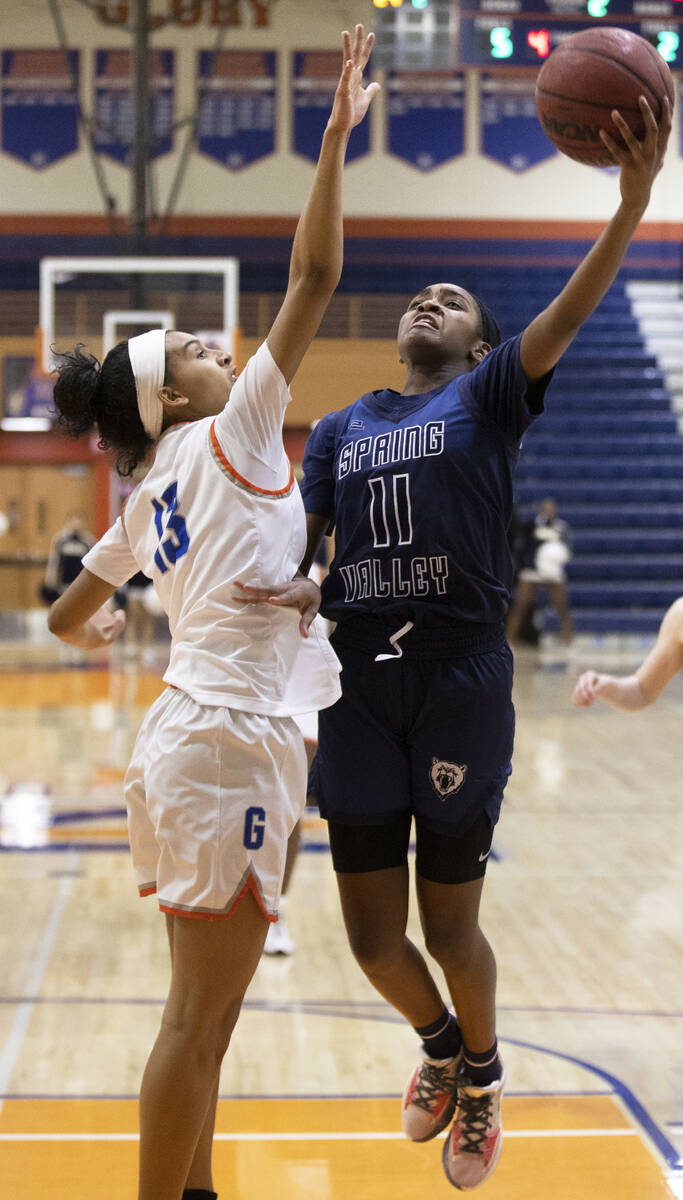 Spring Valley's Jaila Childress (11) drives past Bishop Gorman guard Reina Bell (13) in the fir ...
