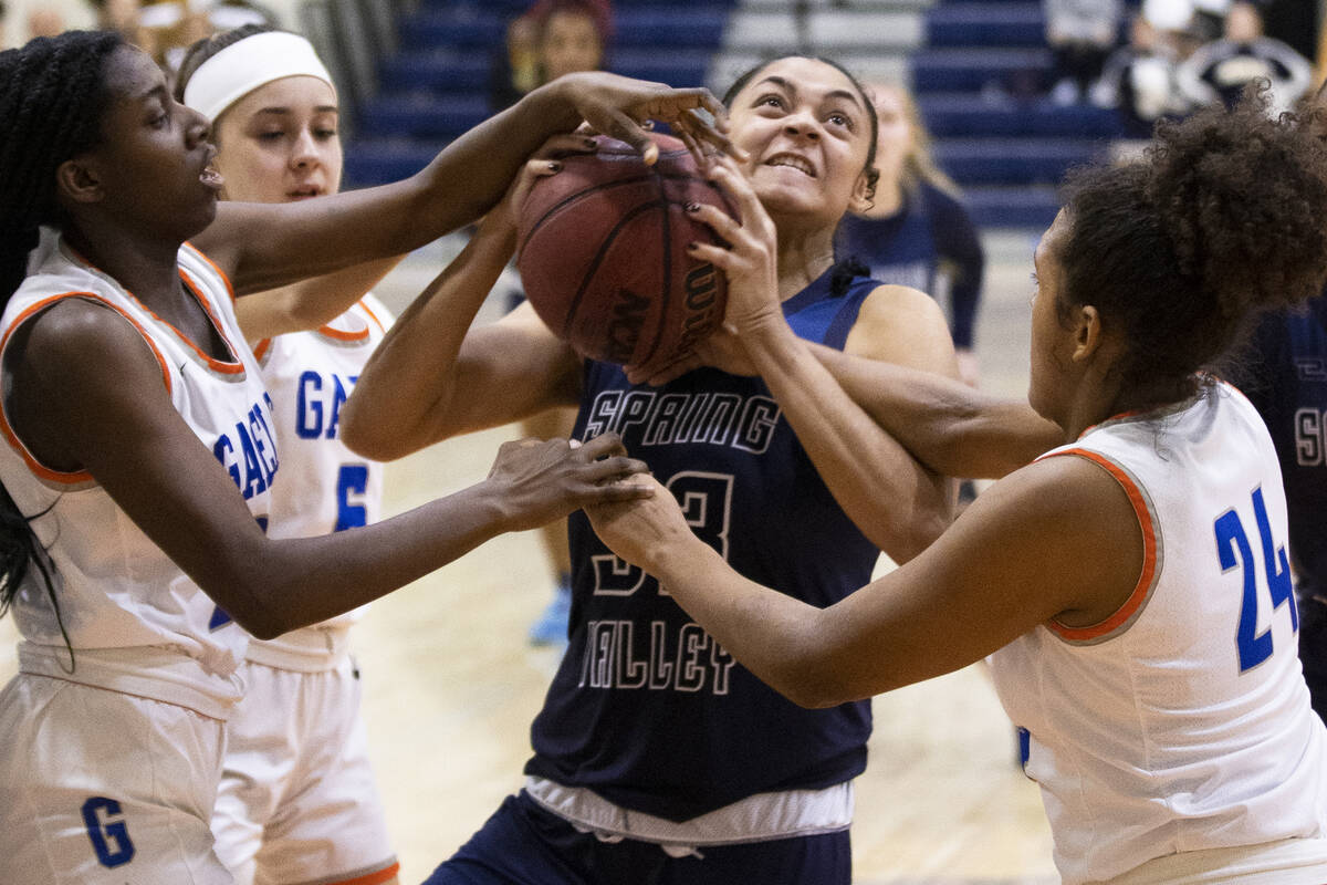 Spring Valley forward Briana Green (33) is fouled by Bishop Gorman forward Shaolin Cooper (24) ...
