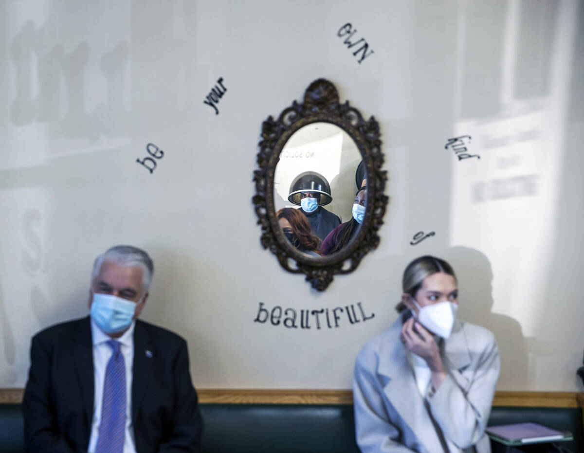 A customer looks on as Gov. Steve Sisolak, left, meets with Black business owners at Illusion S ...