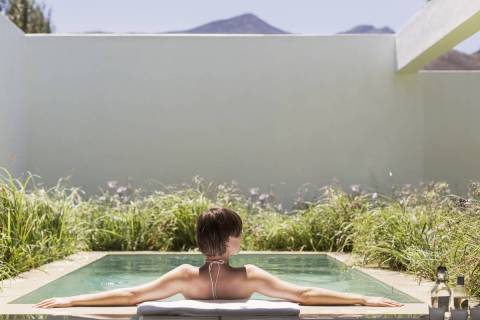 A woman relaxes in her backyard spool, a combination of a spa and pool. (Getty Images)