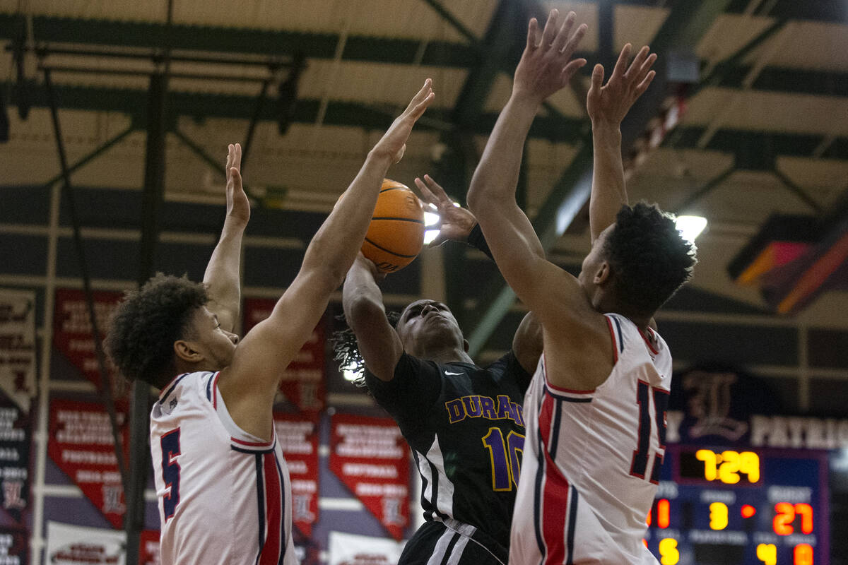 Durango’s Tylen Riley (10) shoots against Liberty’s Isaac Allen (5) and Tommy Bra ...