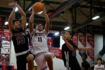 Liberty’s Dedan Thomas (11) shoots against Durango’s Sterling Knox (32) and Mason ...