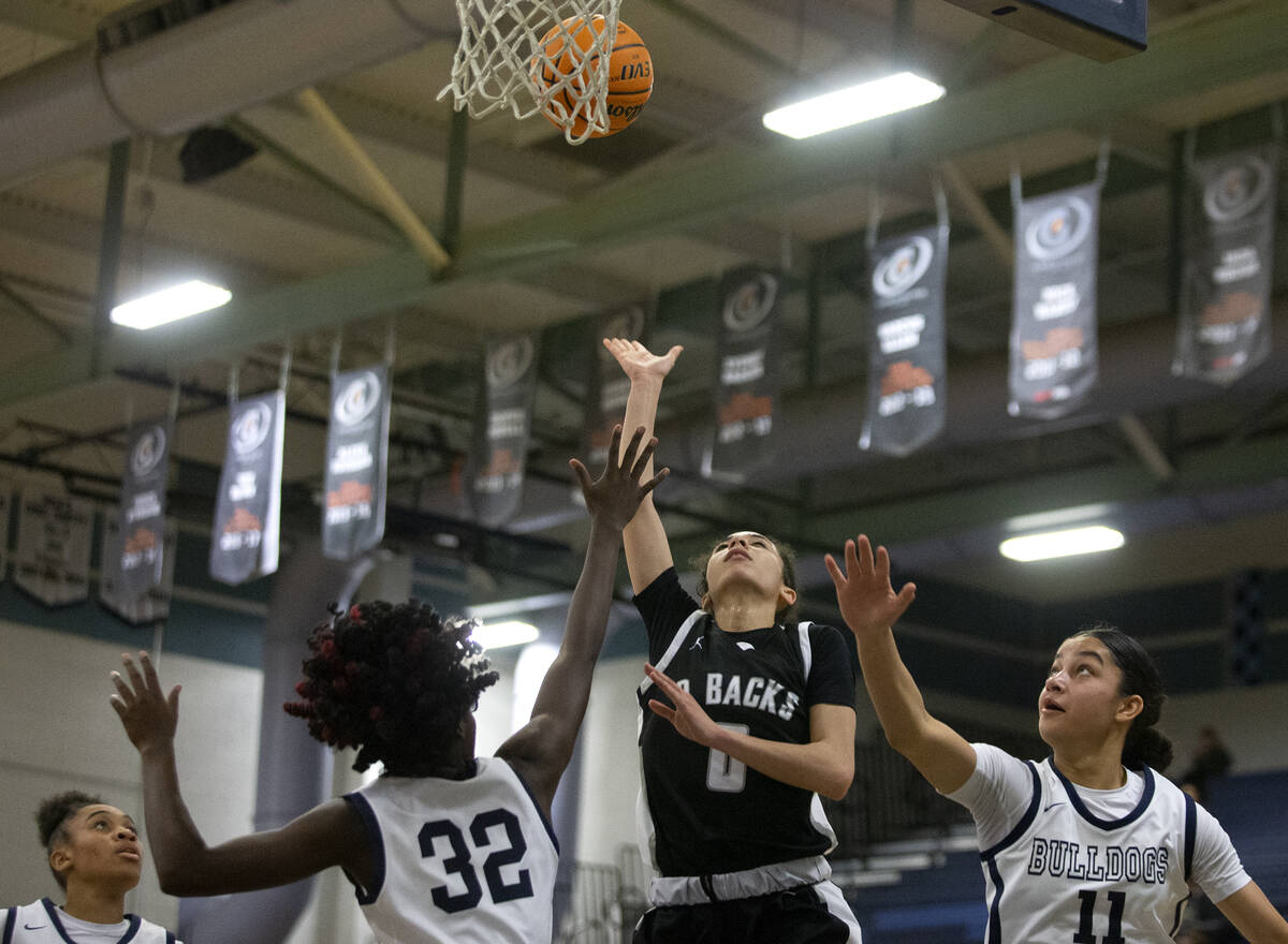 Desert Oasis’ Olivia Bigger (0) shoots against Centennial’s Asani Ceaser (32) and ...