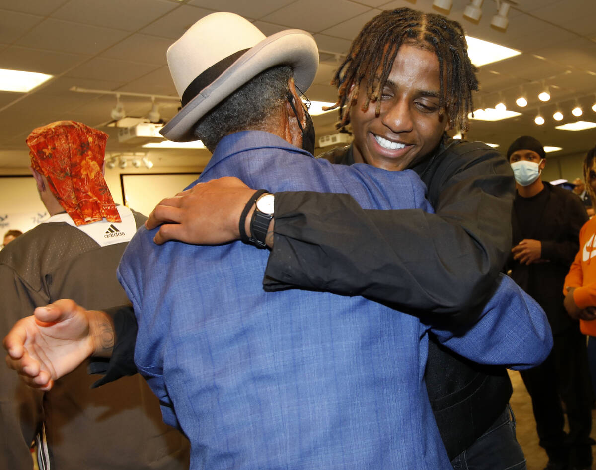 Jesse Wesley Jr., face to the camera, hugs his father Jesse Wesley Sr. after his graduation cer ...