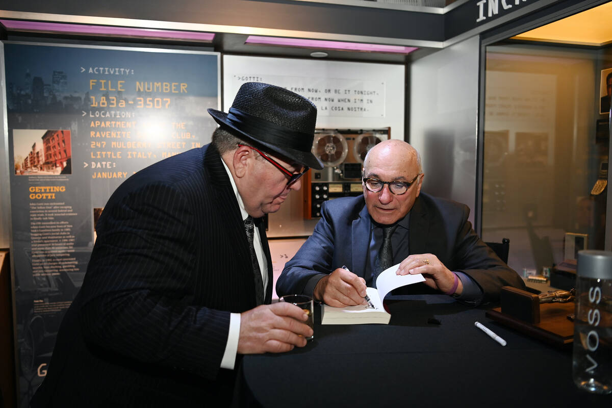 Former FBI agent Joe Pistone (R) signs books during The Mob Museum's 10th Anniversary Fundraisi ...