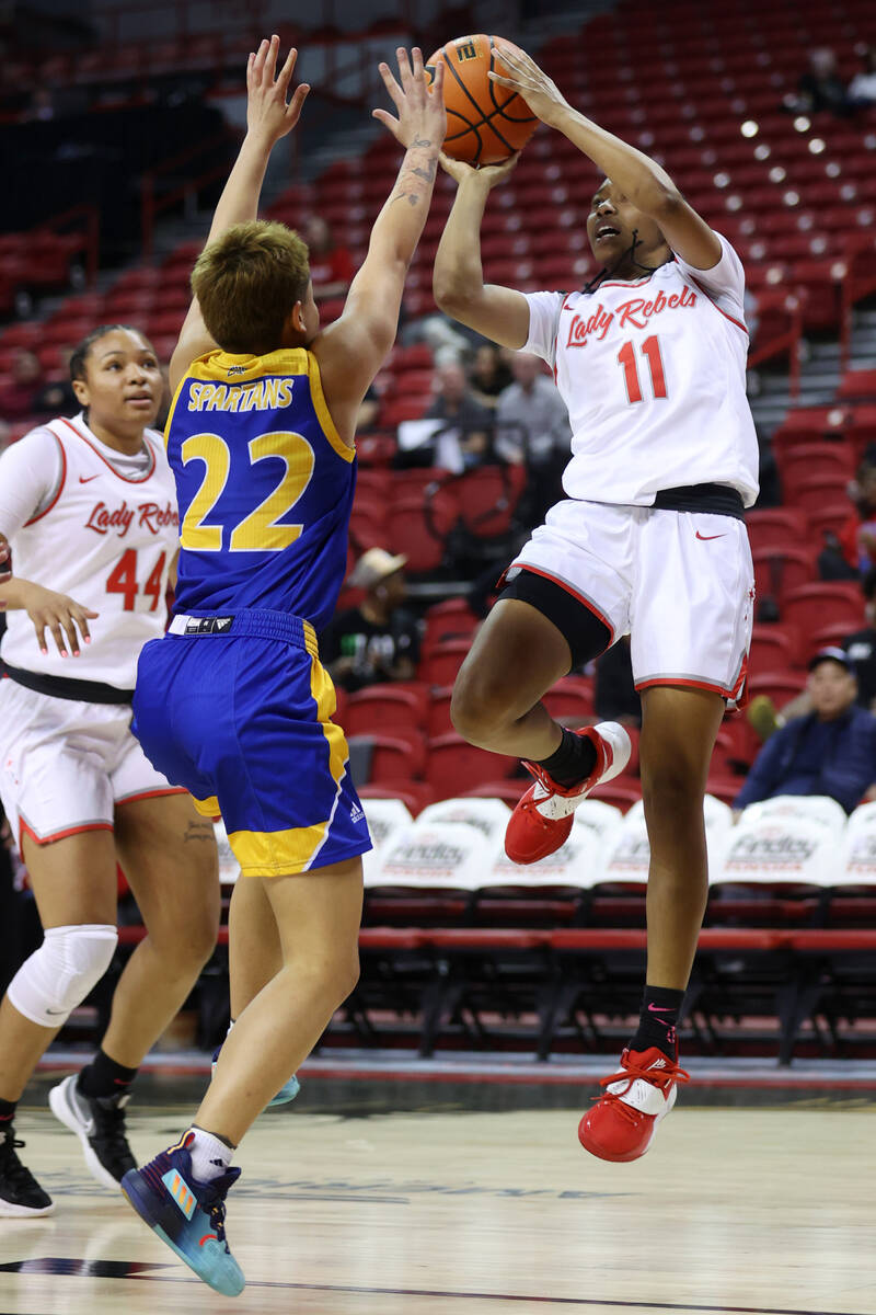 UNLV Lady Rebels Justice Ethridge (11) goes up for a shot under pressure from San Jose Spartans ...