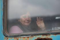 A woman waves from a train carriage to be evacuated to Russia, at the railway station in Debalt ...