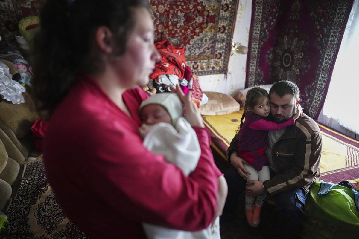 Oleksandr Manha comforts his 4 year-old daughter Sofia as his wife Anastasia Manha, 23, lulls h ...