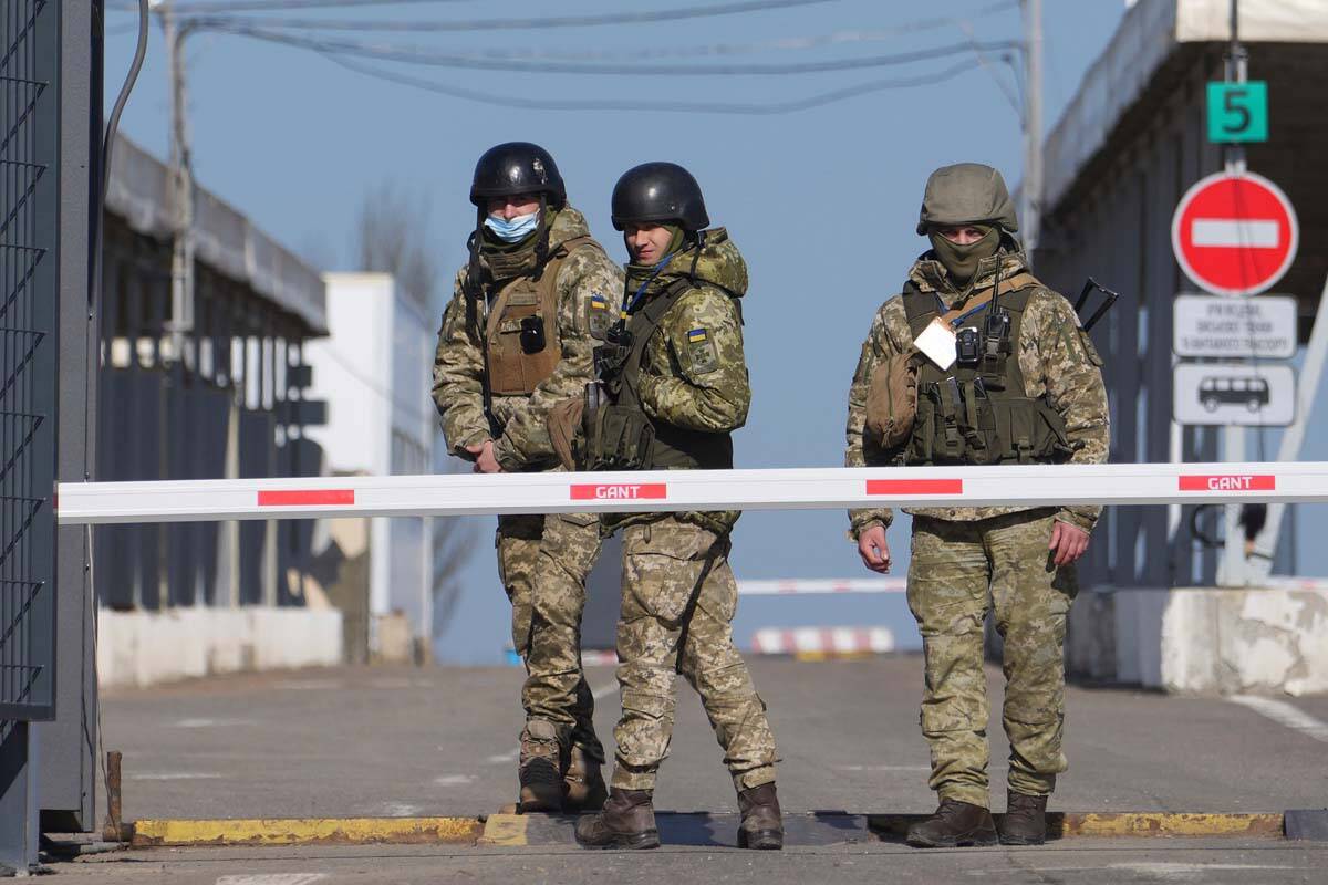Ukrainian border guards stand at a checkpoint from territory controlled by Russia-backed separa ...