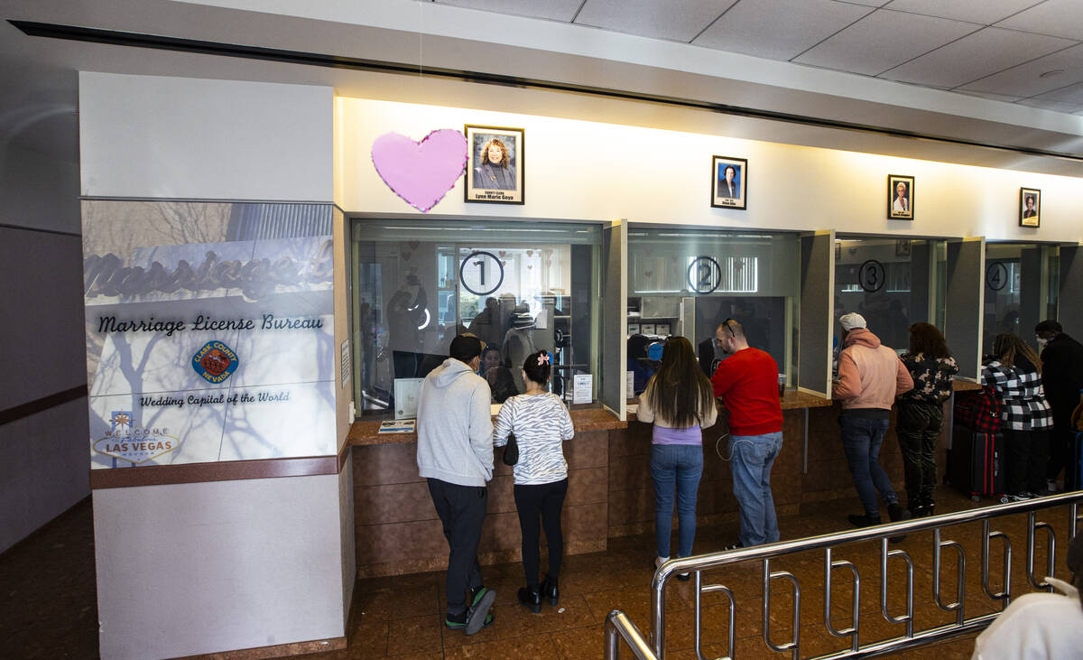 People visit with clerks at the Clark County Marriage License Bureau on Monday, Feb. 21, 2022, ...