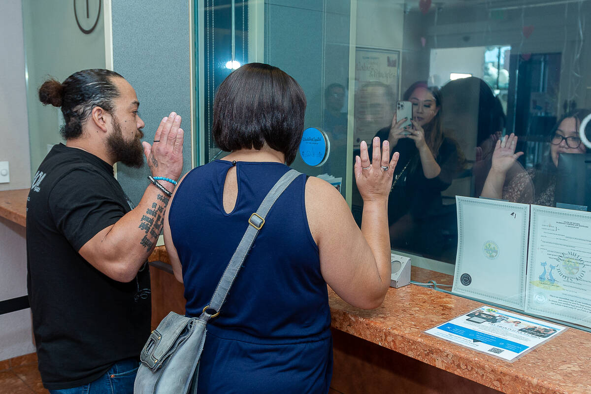 Mayra Ramirez and Luis Pantoja take an oath when receiving their marriage license at the Clark ...