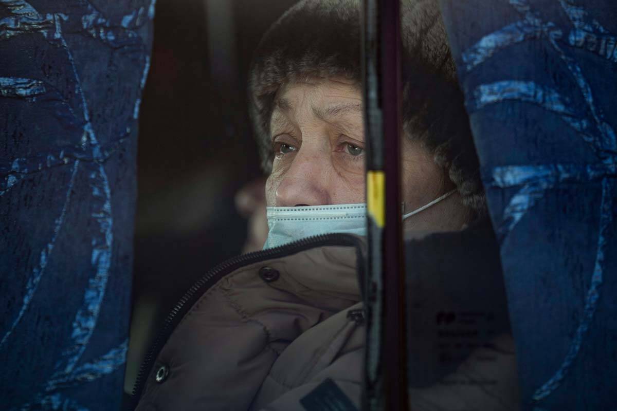A woman sits on a bus after crossing from pro-Russian separatists controlled territory to Ukrai ...