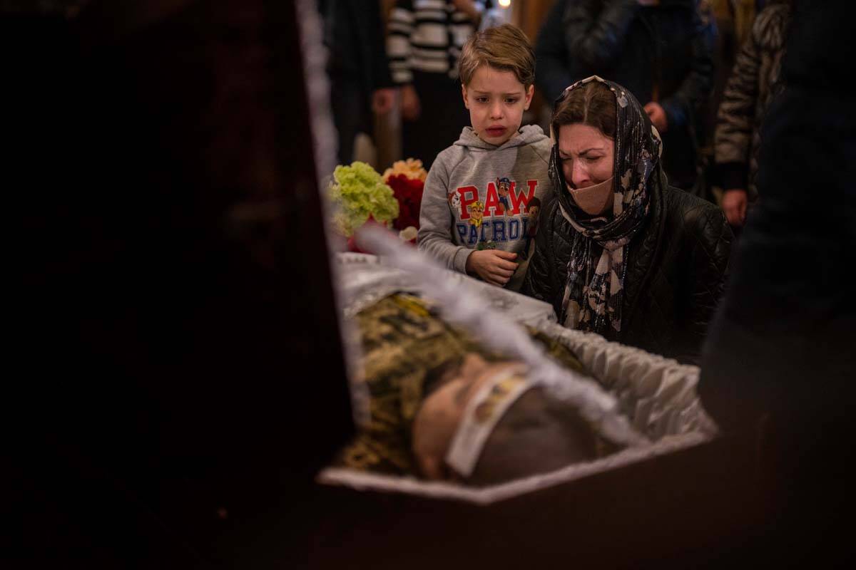 A woman and a boy react next to the body of Ukrainian Army captain Anton Sydorov, 35, killed in ...