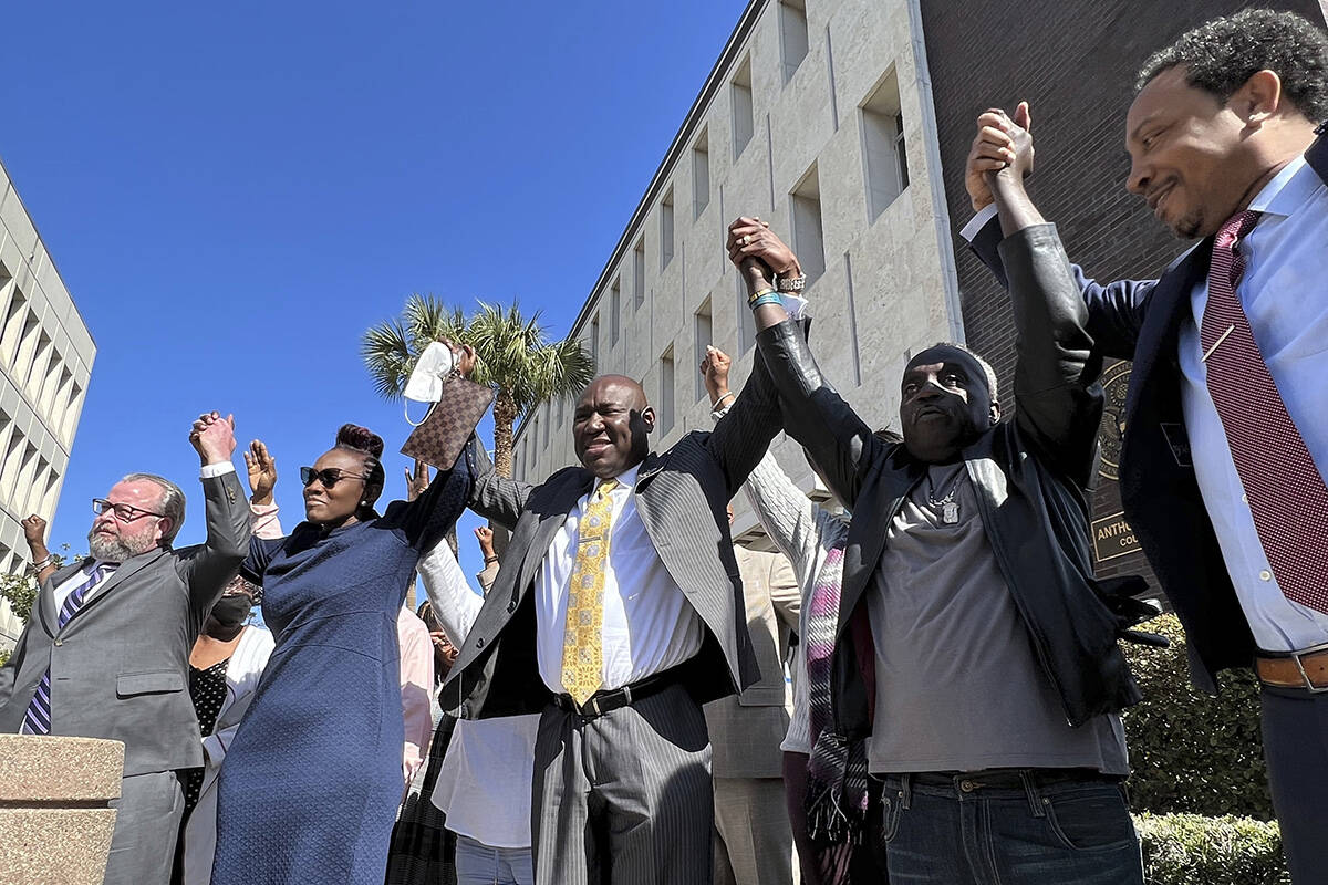 The family and attorneys of the Ahmaud Aubery raise their arms in victory after all three men w ...
