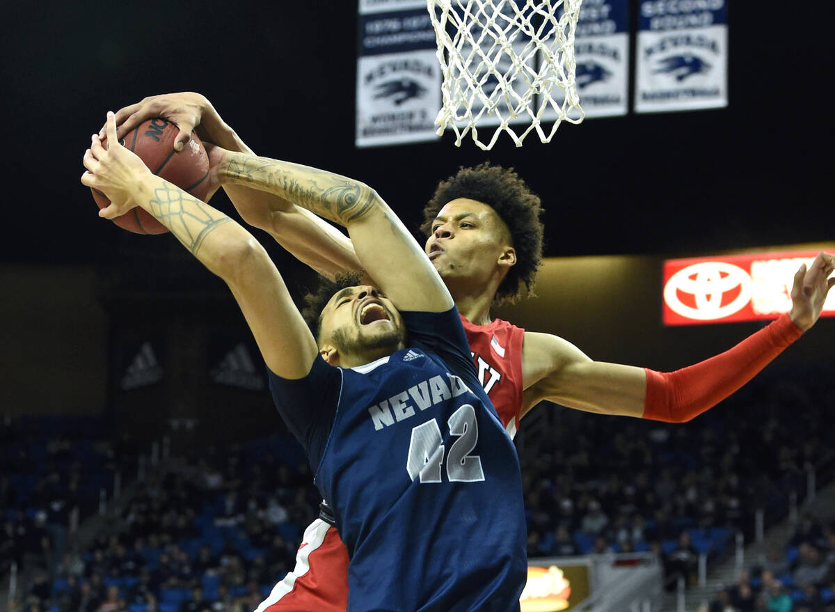 UNLV's David Muoka block a shot by Nevada's K.J. Hymes during Tuesday game at Lawlor Events Cen ...