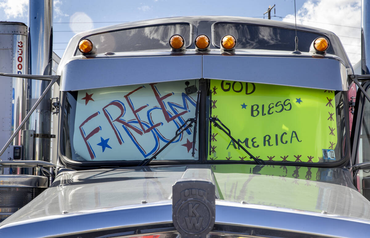 Signs decorate the front windows of semi trucks arriving for The People’s Convoy staging ...