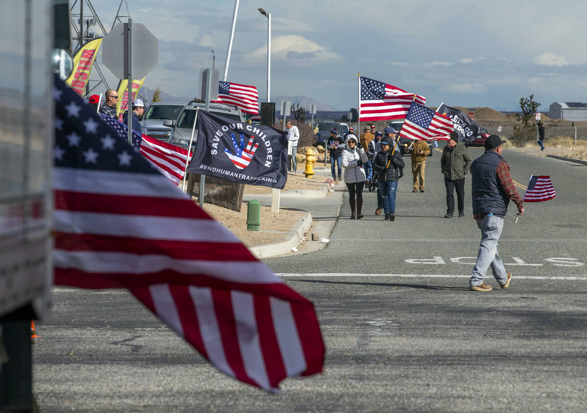 Attendees carry flags while arriving for a departure event for The People’s Convoy at Adelant ...