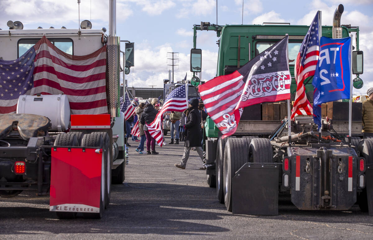 Flags and signs are plentiful during a departure event for The People’s Convoy at Adelanto St ...