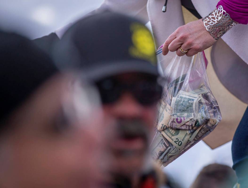 Attorney Leigh Dundas takes monetary donations from attendees as a departure event wraps up for ...