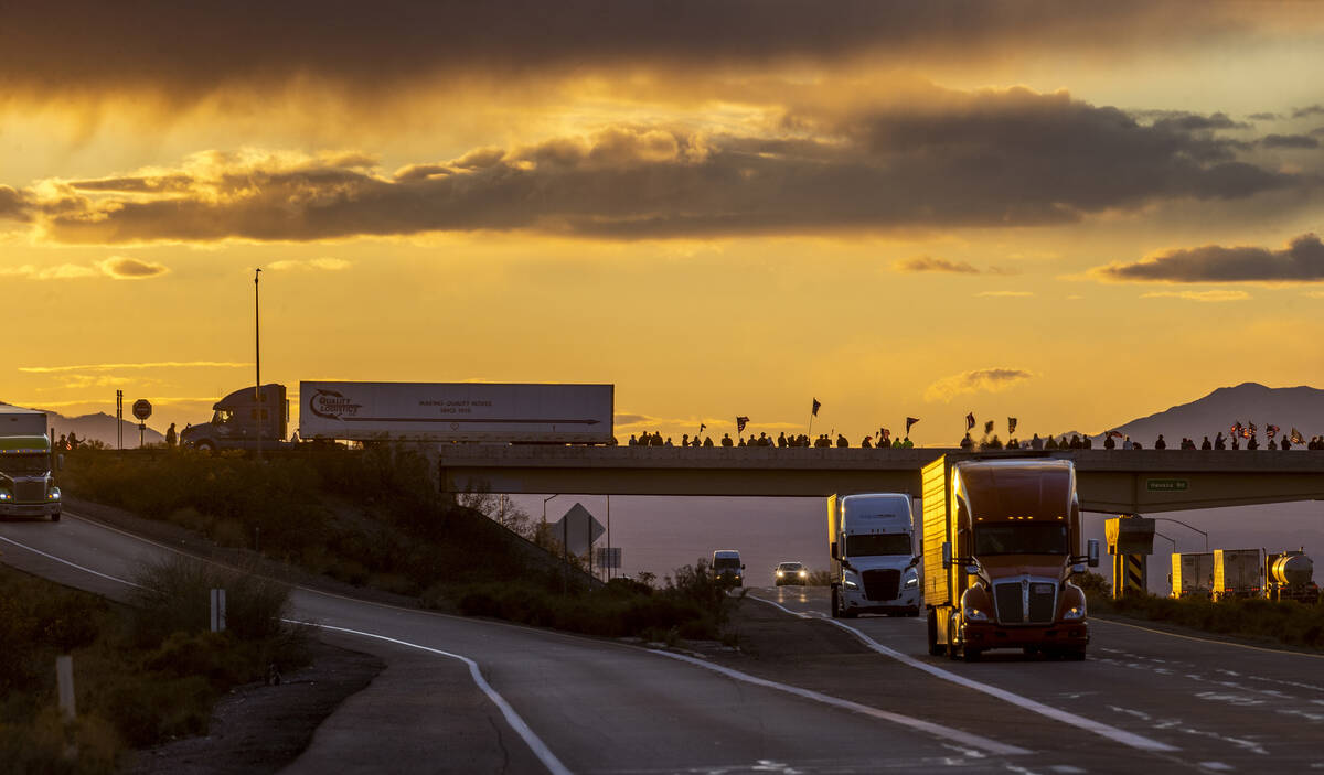 Supporters line an I-40 overpass at sunset in Arizona nearly 20 miles out of Kingman awaiting T ...