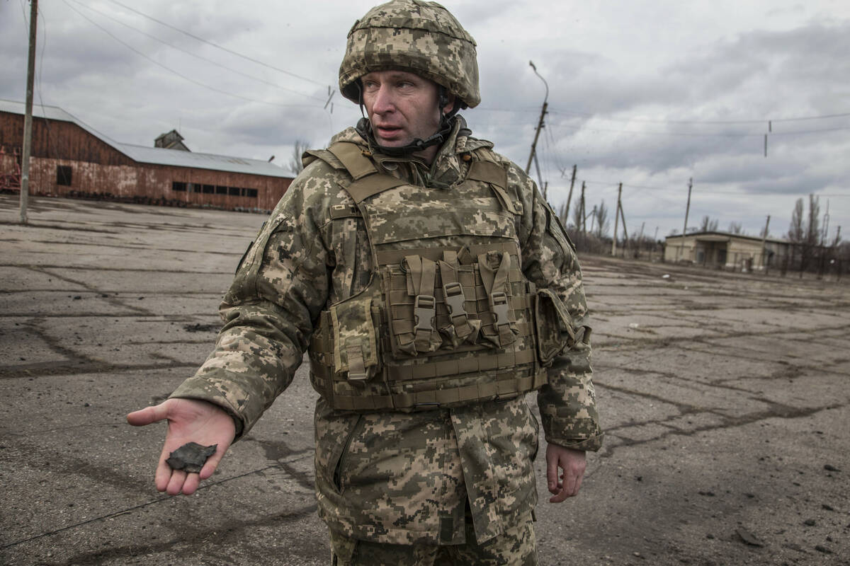 Ukrainian Army general Mykhailo Dropaty displays a shell fragment after shelling by pro-Russian ...