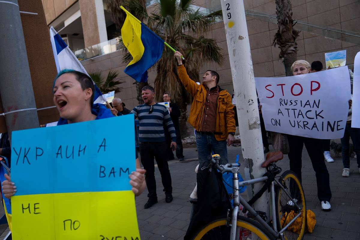 Demonstrators hold placards and flags as they attend a pro-Ukraine protest outside the Russian ...