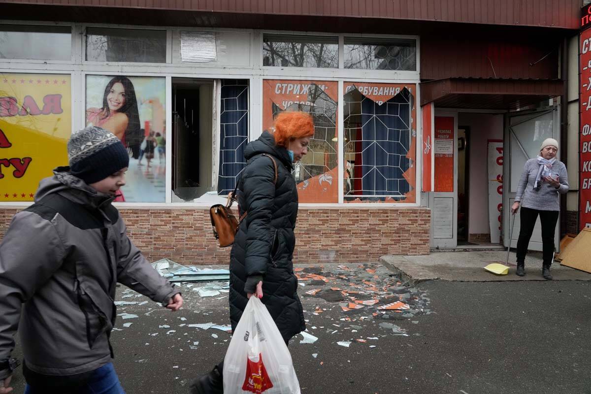 People walk past the aftermath of Russian shelling in Kyiv, Ukraine, Thursday, Feb. 24, 2022. R ...