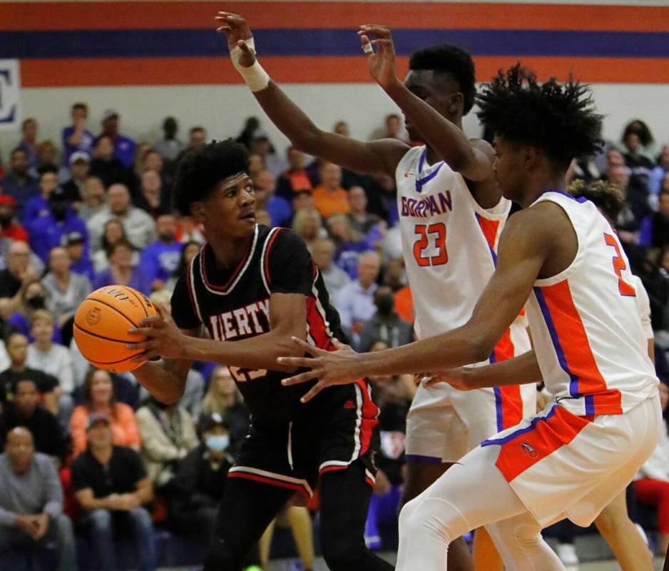 Liberty High School's Angelo Kambala (2) keeps a ball away from Bishop Gorman High School's Chr ...