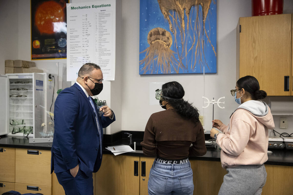 U.S. Secretary of Education Miguel Cardona, far left, speaks to chemistry class students during ...