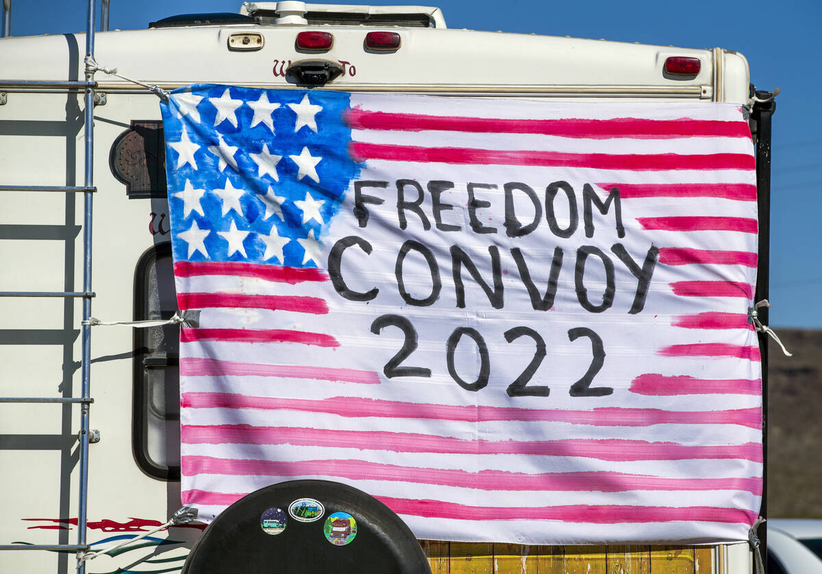 A sign hangs on the back of an RV apart of The People’s Convoy fueling up at Crazy Freds ...